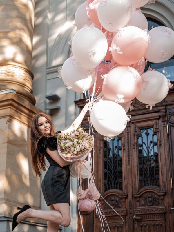 Woman with bunch of pink balloons